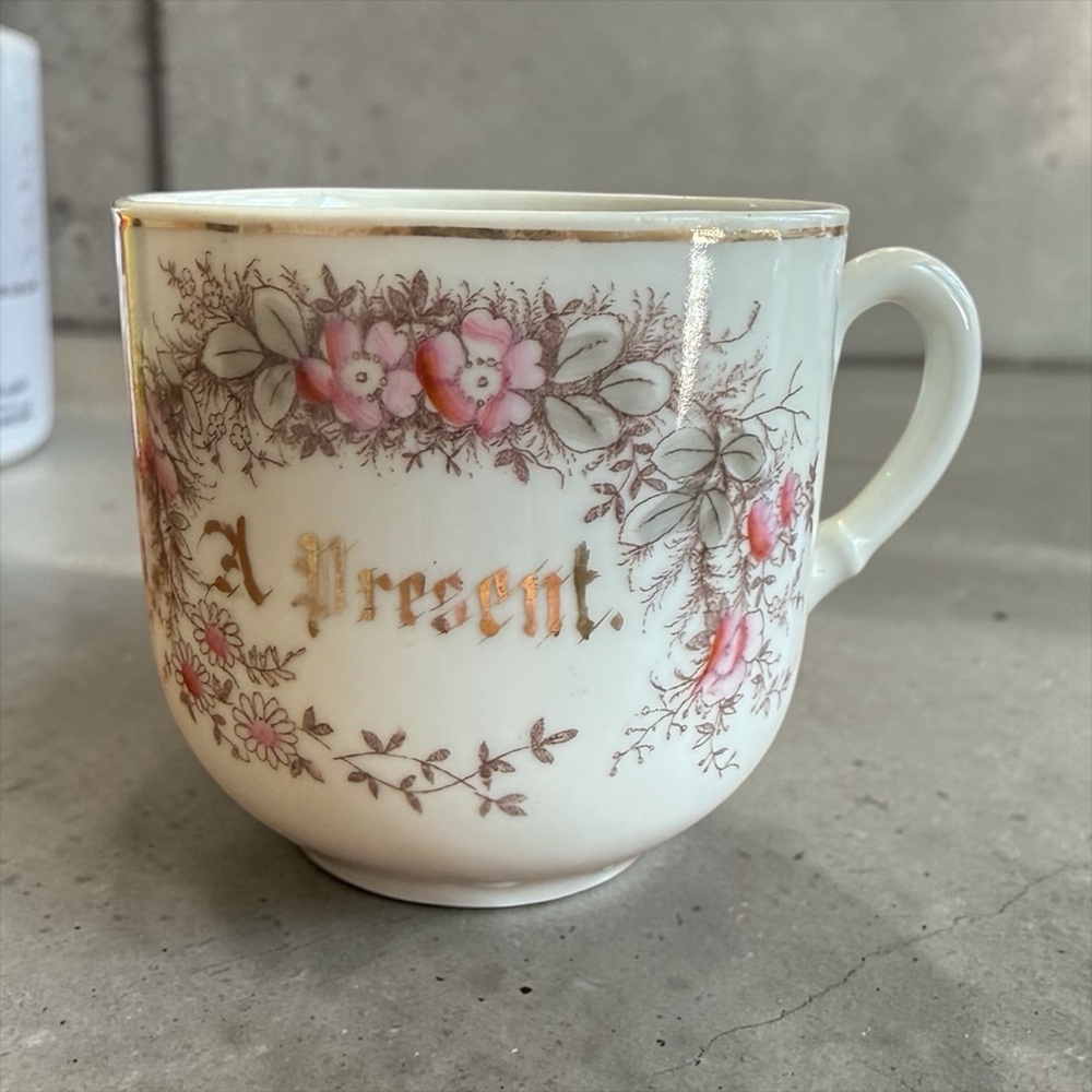 Antique or vintage collectible souvenir teacup featuring a floral pattern